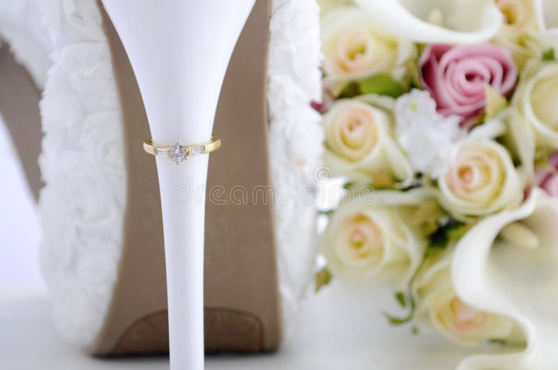 Wedding ring on beautiful white stiletto shoe heel.