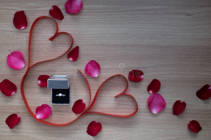 Wedding ring and two red heart ribbon with pink and red rose pet