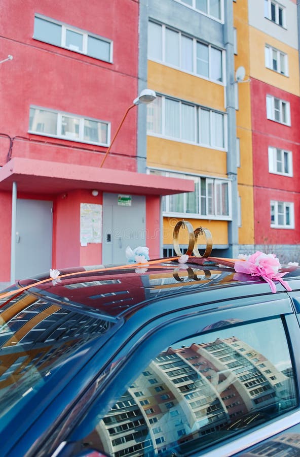 Wedding rings with bells on the roof of the car, against the background of urban buildings. Traditional Russian decoration of a stock photos Wedding rings with bells on the roof of the car, against the background of urban buildings. Traditional Russian decoration of a stock photos