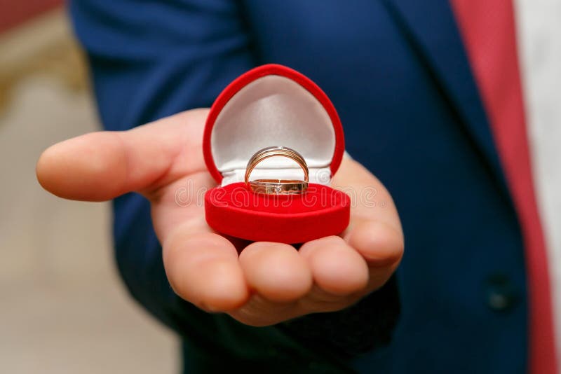 Wedding rings in red box in the hand of the groom. 