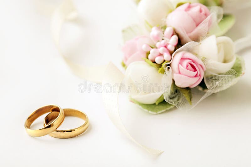 Two golden wedding rings and flowers