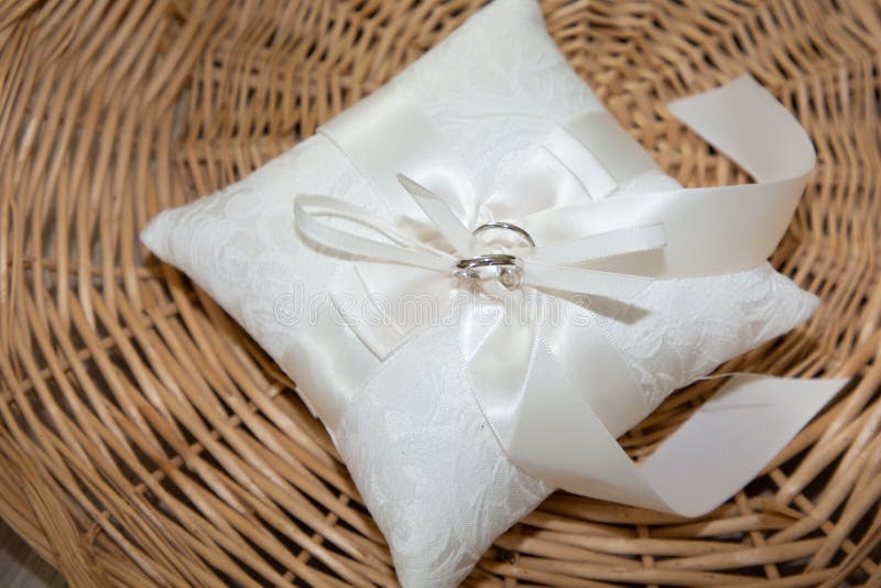 Wedding Rings on a White Silk Cushion Placed on a Basket Rustic Stock