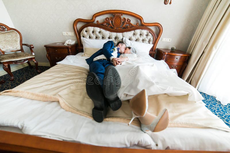 Wedding Shot Of Bride And Groom Lying In Stylish Bed