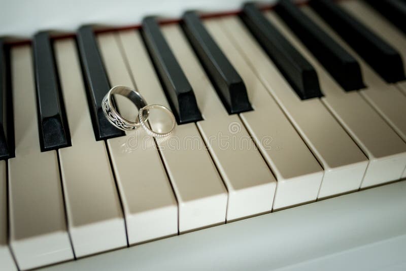 Wedding silver rings lying on the piano keys