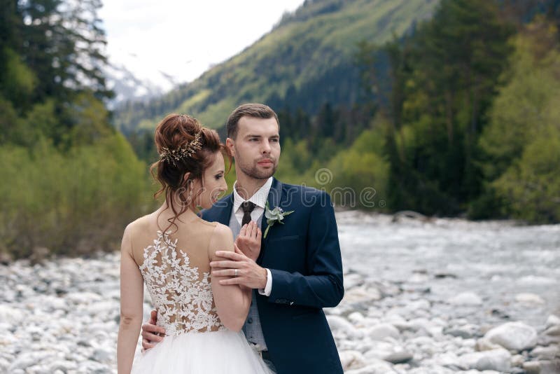 Wedding Weg Die Braut und der Bräutigam gehen entlang die Flussbank und halten sich ` s Hände Portrait der Braut und des Bräutiga stockbild Wedding Weg Die Braut und der Bräutigam gehen entlang die Flussbank und halten sich ` s Hände Portrait der Braut und des Bräutiga stockbild