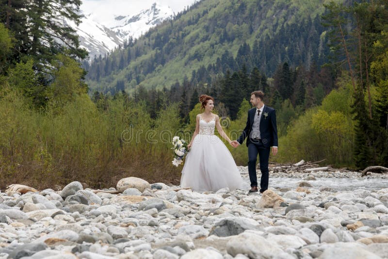 Wedding Weg Die Braut und der Bräutigam gehen entlang die Flussbank und halten sich ` s Hände Portrait der Braut und des Bräutiga stockfotos Wedding Weg Die Braut und der Bräutigam gehen entlang die Flussbank und halten sich ` s Hände Portrait der Braut und des Bräutiga stockfotos