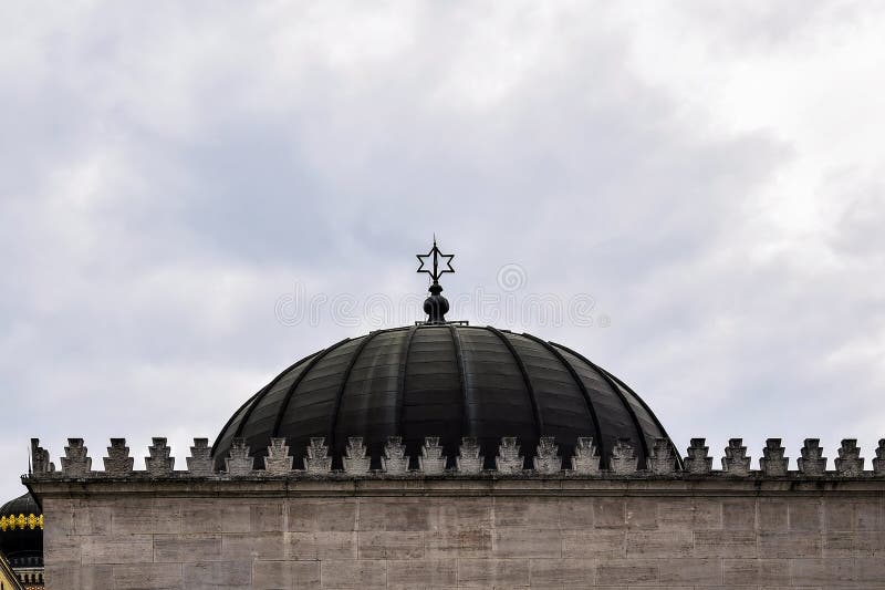 Weergeven van de koepel van de synagoge met een ster van David op een bewolkte hemelachtergrond De Grote synagoge van Boedapest i stock afbeelding Weergeven van de koepel van de synagoge met een ster van David op een bewolkte hemelachtergrond De Grote synagoge van Boedapest i stock afbeelding