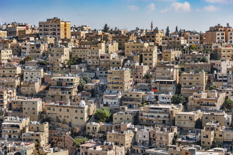 Weergeven van de roze vierkante blokken van de stad van Amman, van een hoog standpunt, op de achtergrond een duidelijke blauwe he stock afbeelding Weergeven van de roze vierkante blokken van de stad van Amman, van een hoog standpunt, op de achtergrond een duidelijke blauwe he stock afbeelding
