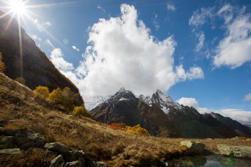 Weergeven van Ine-piek en Dzhuguturluchat-berg bij de herfst stock afbeelding Weergeven van Ine-piek en Dzhuguturluchat-berg bij de herfst stock afbeelding
