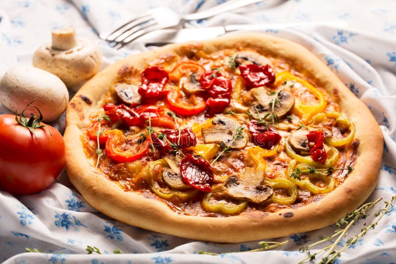 Vegan pizza with vegetables on a rustic stile tablecloth. Vegan pizza with vegetables on a rustic stile tablecloth