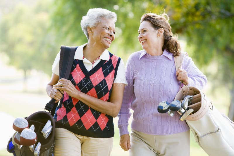 Weibliche Freunde, die ein Spiel des Golfs genießen stockfotos Weibliche Freunde, die ein Spiel des Golfs genießen stockfotos