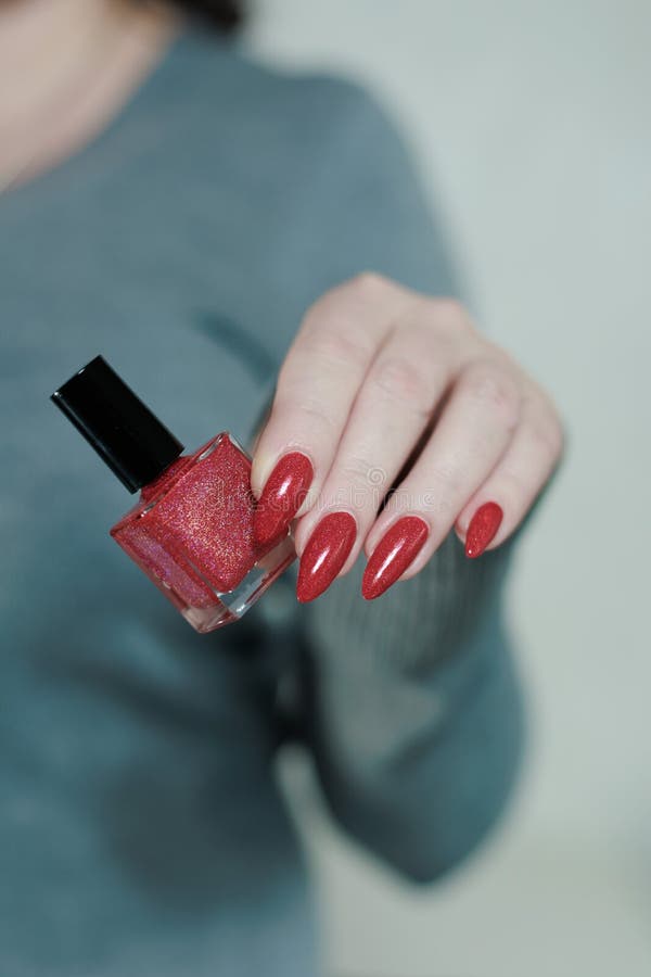 Weibliche Hand mit langen Nägeln und dunkelrote Maniküre stockfotografie