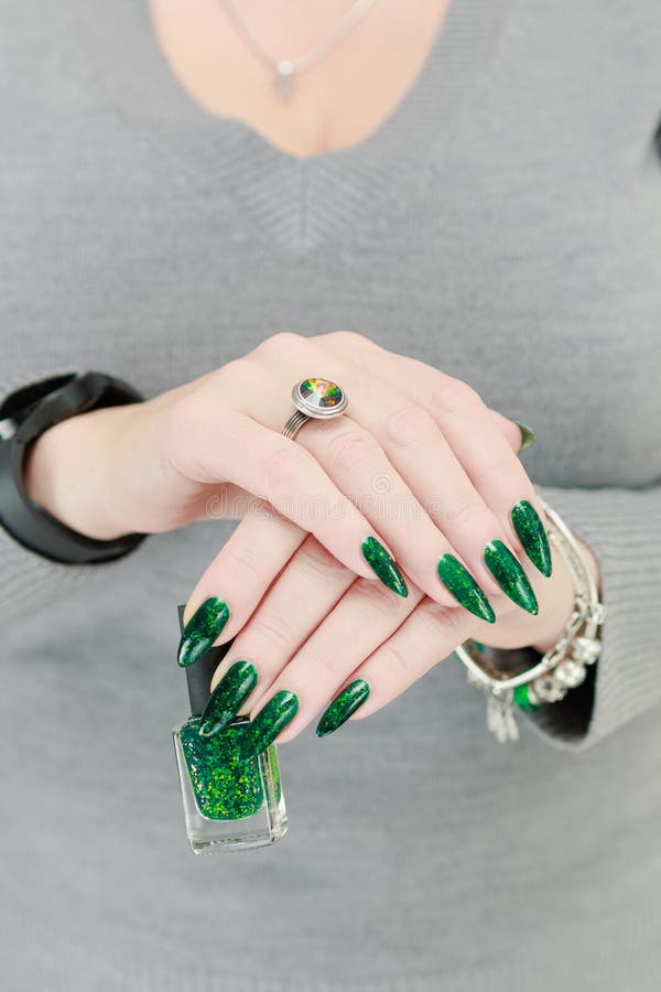 Weibliche Hand mit langen Nägeln und grüner Maniküre stockbild
