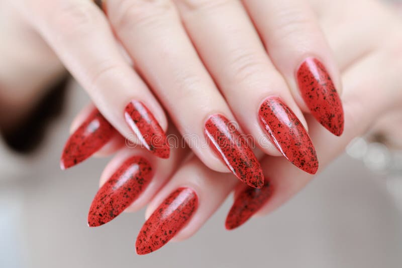 Weibliche Hand mit langen Nägeln und hellroter Maniküre stockfoto