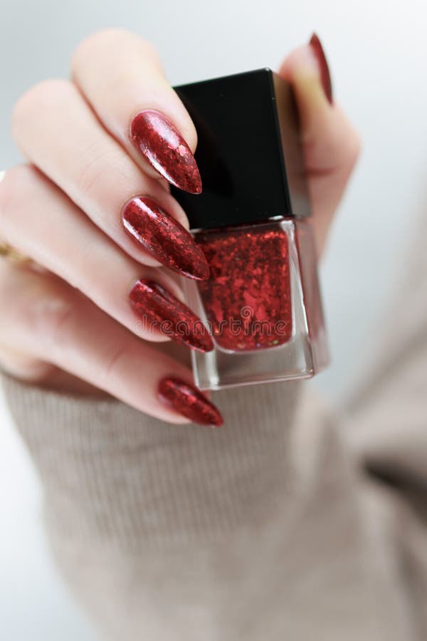 Weibliche Hand mit langen Nägeln und roter Maniküre stockfotografie