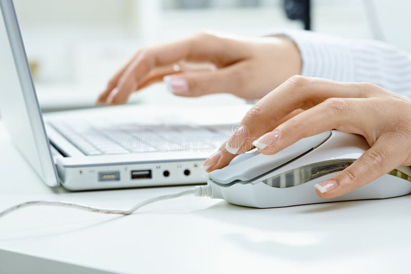 Weibliche Hand unter Verwendung der Computermaus stockbilder