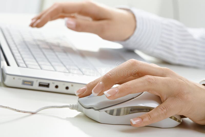Weibliche Hand unter Verwendung der Computermaus lizenzfreie stockbilder