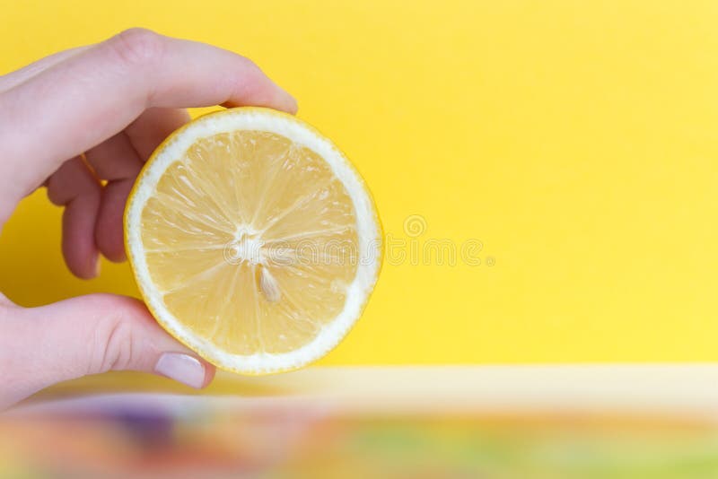 Weibliche Handholdinghälfte Zitrone auf gelber gesunder ernährung und Diätkonzept. Weibliche Handholdinghälfte Zitrone auf gelber gesunder ernährung und Ernährung conceptfree Raum für Text.