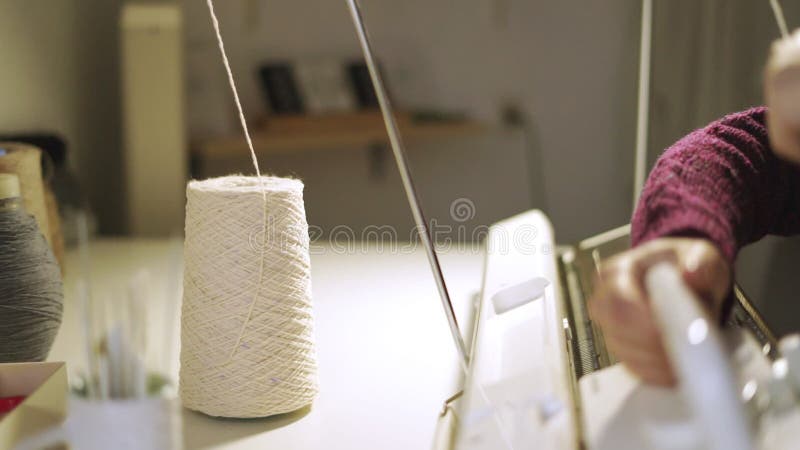 Weibliche Handspinnendes Gewebe auf Strickmaschine in der Werkstatt