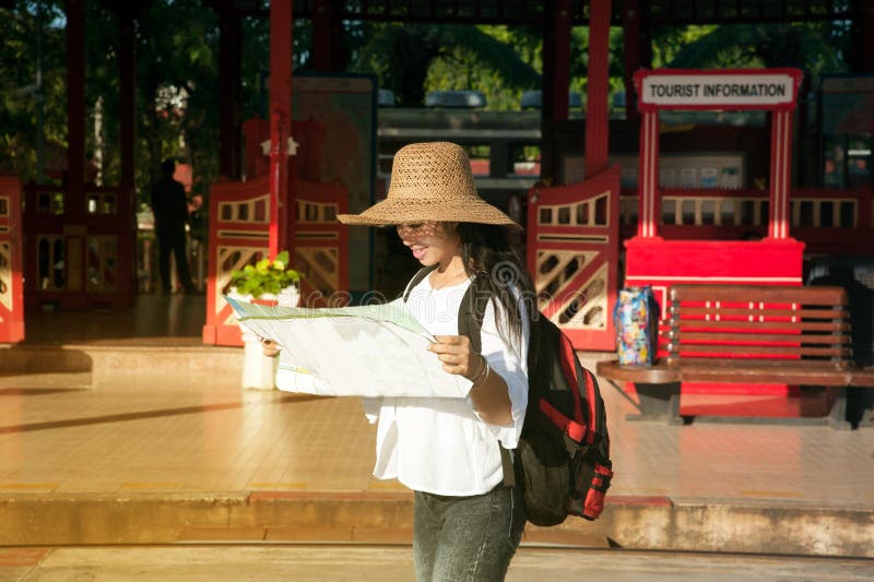 Weibliche schauende Karte des recht asiatischen Reisendwanderers am Bahnhof lizenzfreies stockbild Weibliche schauende Karte des recht asiatischen Reisendwanderers am Bahnhof lizenzfreies stockbild