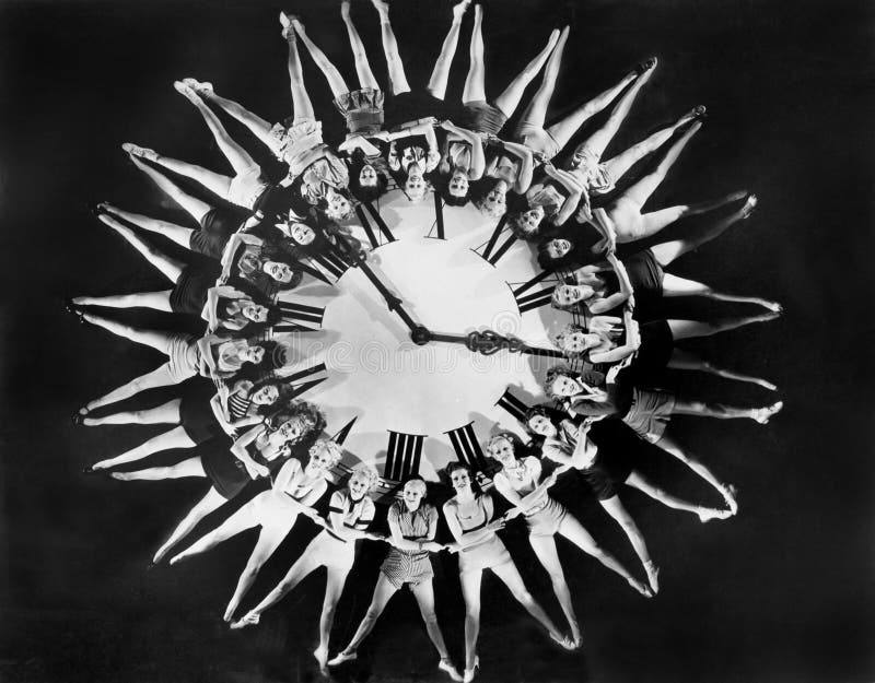 Weibliche Tänzer, die enorme Uhr einkreisen (alle dargestellten Personen sind nicht längeres lebendes und kein Zustand existiert