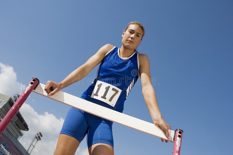 Weiblicher Athlet Standing at Hurdle Stockbild Bild von niedrig