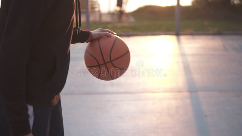 Weiblicher Basketballbasketball-spieler, der den Ball aufprallt Zeitlupe schoss vom Basketball-Spieler-Training auf dem Freien