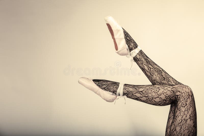 Beautiful woman ballet dancer, part of body legs in shoes and black lace tights studio shot on gray background. Beautiful woman ballet dancer, part of body legs in shoes and black lace tights studio shot on gray background