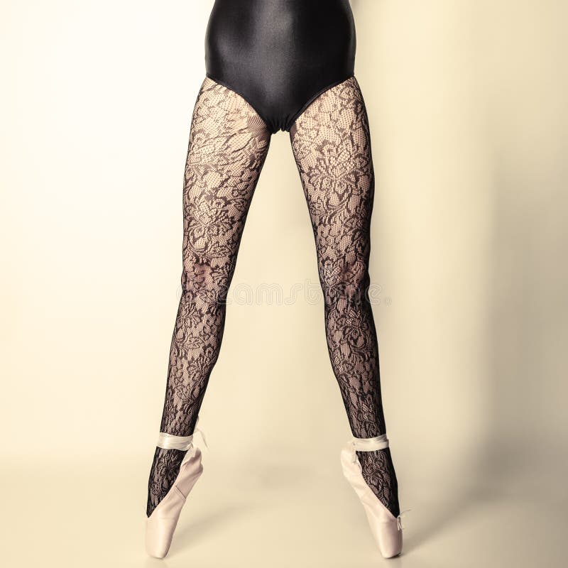 Beautiful woman ballet dancer, part of body legs in shoes and black lace tights studio shot on gray background. Beautiful woman ballet dancer, part of body legs in shoes and black lace tights studio shot on gray background