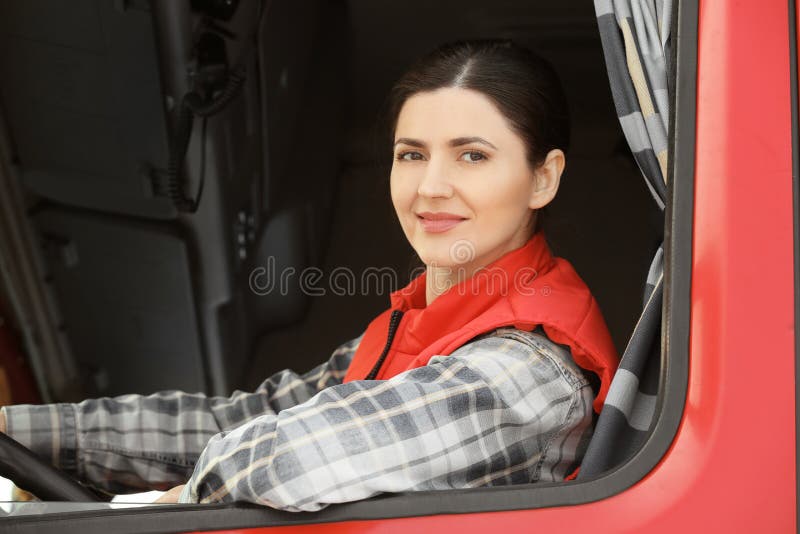 Weiblicher Fahrer, der aus LKW heraus schaut stockfoto Weiblicher Fahrer, der aus LKW heraus schaut stockfoto
