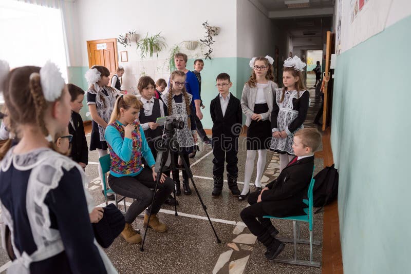 Weiblicher Fotograf macht Fotos von intelligenten Erstsortierern nach den Lektionen im Schulkorridor stockfotografie Weiblicher Fotograf macht Fotos von intelligenten Erstsortierern nach den Lektionen im Schulkorridor stockfotografie