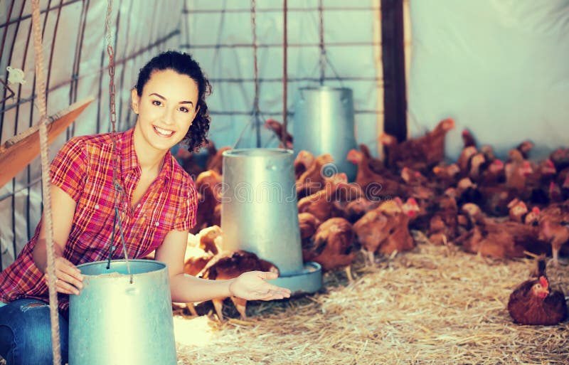 Weiblicher Landwirt, der Eimer mit Futter hält lizenzfreies stockbild Weiblicher Landwirt, der Eimer mit Futter hält lizenzfreies stockbild