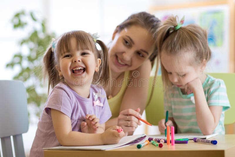 Weiblicher Lehrer, der mit Kindern im Vorschulklassenzimmer arbeitet lizenzfreie stockbilder Weiblicher Lehrer, der mit Kindern im Vorschulklassenzimmer arbeitet lizenzfreie stockbilder