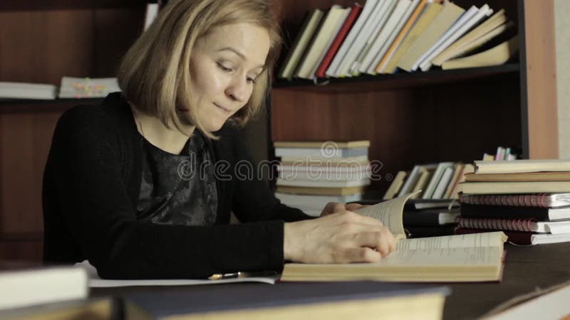 Weiblicher Lektor, der mit Büchern in einer Bibliothek im College arbeitet Müder Student, der für Prüfungen sich vorbereitet