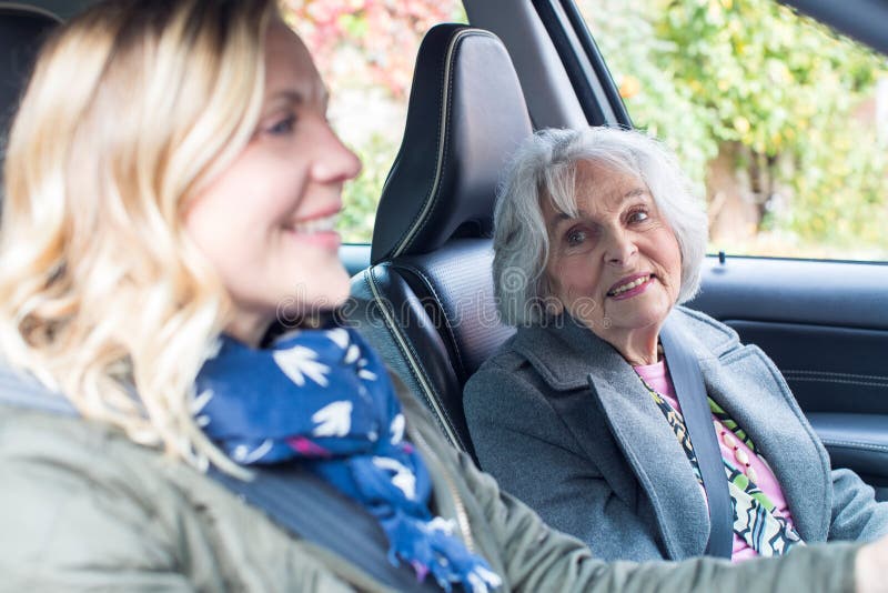 Weiblicher Nachbar, der älterer Frau einen Aufzug im Auto gibt lizenzfreies stockbild Weiblicher Nachbar, der älterer Frau einen Aufzug im Auto gibt lizenzfreies stockbild