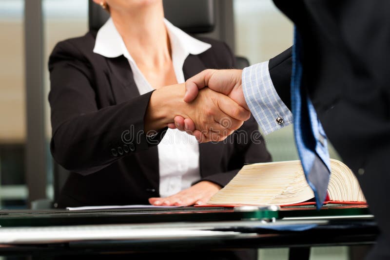 Mature female lawyer or notary with client in her office - handshake. Mature female lawyer or notary with client in her office - handshake