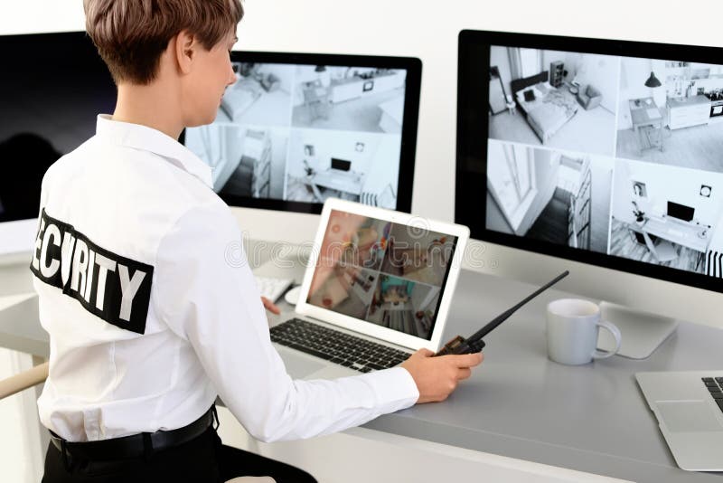 Weiblicher Sicherheitsbeamte mit dem tragbaren Übermittler, der Hauptkameras überwacht lizenzfreie stockbilder Weiblicher Sicherheitsbeamte mit dem tragbaren Übermittler, der Hauptkameras überwacht lizenzfreie stockbilder