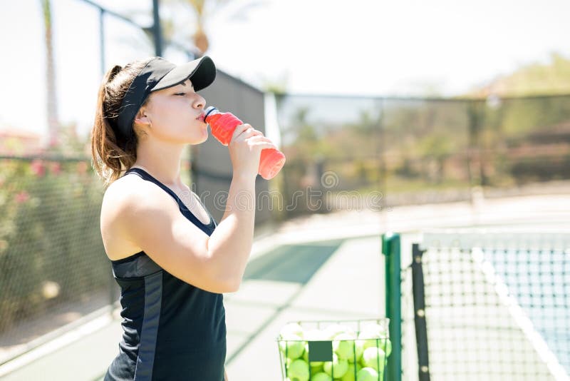 Weiblicher Tennisspieler, der Energiegetränk hat stockbilder Weiblicher Tennisspieler, der Energiegetränk hat stockbilder