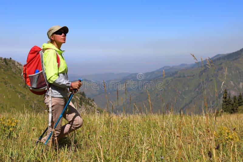 Weiblicher Tourist steht mitten in einer Wiese lizenzfreie stockfotografie Weiblicher Tourist steht mitten in einer Wiese lizenzfreie stockfotografie