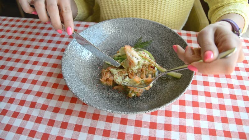 Weibliches Handmesser und Gabel und Platte mit Thunfischsalat, Eier, frische Salatblätter, schöne Diätnahrung