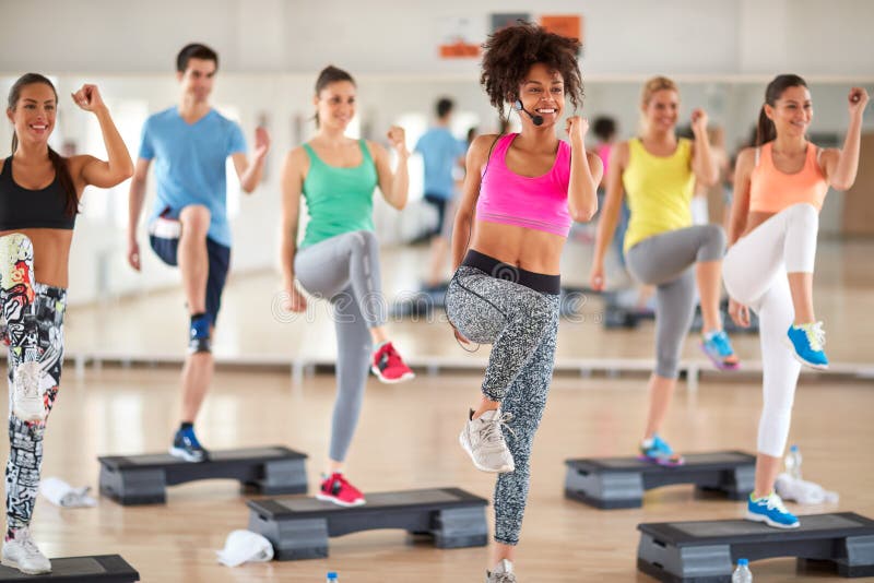 Afro-American female trainer lead group training in fitness center. Afro-American female trainer lead group training in fitness center