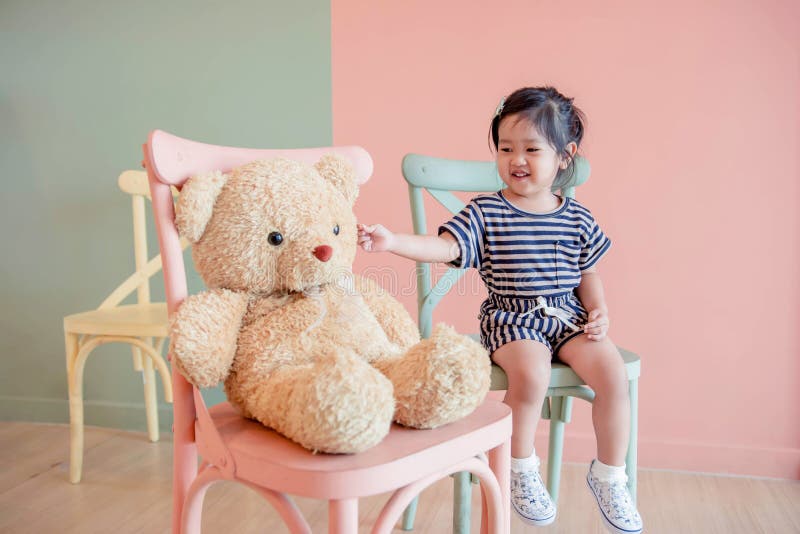 Weichzeichnung eines zwei Jahr-alten Kindes, das mit ihrem Teddy Bear sitzt lizenzfreie stockfotografie