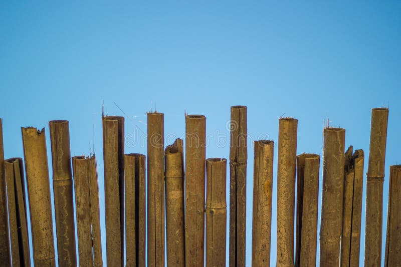 Weidendachstrandschirm und blauer Himmel. natürlicher Bambussonnenschutz und Sommerregenschirmsonnenschirm auf dem blauen Seeufer lizenzfreie stockfotografie