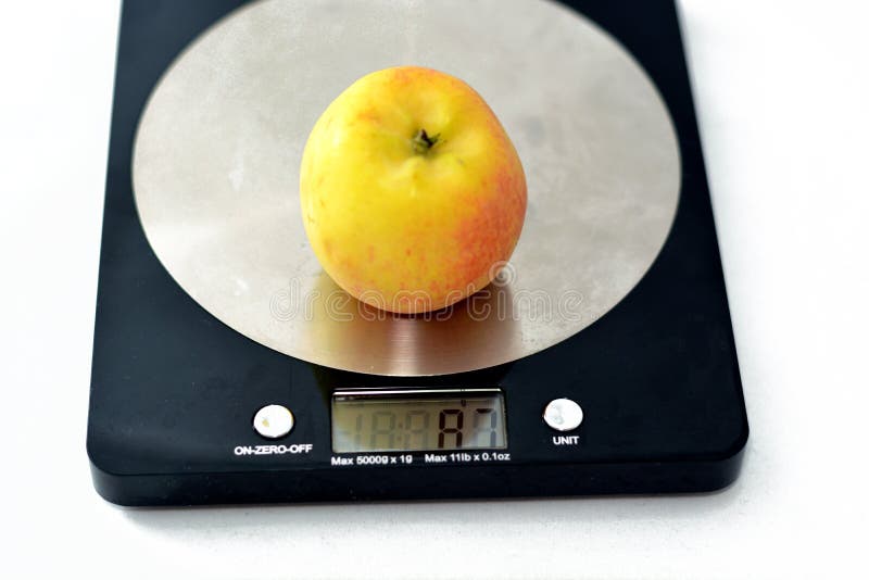 Weighing an Apple Fruit on a Digital Kitchen Scale in Grams on