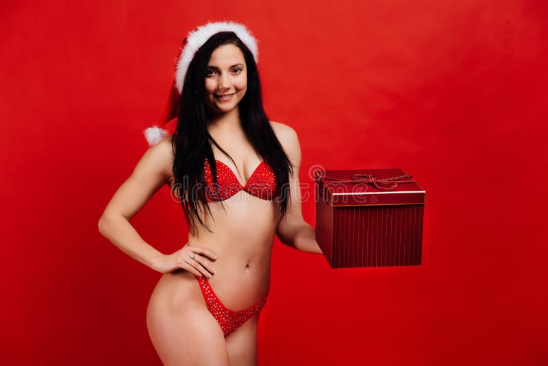 Weihnachten, neues Jahr ` s Feiertage Schönes Mädchen des sexy Sports im Bikini Weihnachtsmann mit Geschenkbox stockbild Weihnachten, neues Jahr ` s Feiertage Schönes Mädchen des sexy Sports im Bikini Weihnachtsmann mit Geschenkbox stockbild