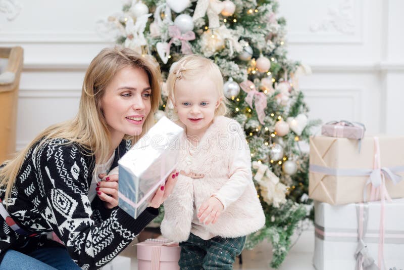 Weihnachts- oder des neuen Jahresfeier Glückliche Mutter gibt das Tochtergeschenk, das mit Band verziert wird stockbilder Weihnachts- oder des neuen Jahresfeier Glückliche Mutter gibt das Tochtergeschenk, das mit Band verziert wird stockbilder