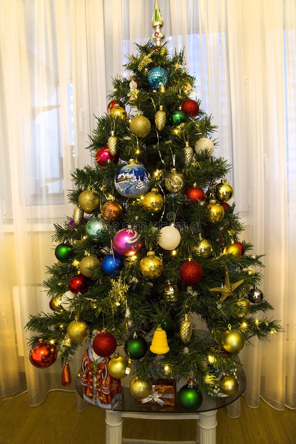 Weihnachtsbaum mit leuchtend farbenfrohen Spielzeug auf dem Hintergrund des Fensters in der Wohnung verziert Urlaub, Weihnachten, lizenzfreie stockfotos Weihnachtsbaum mit leuchtend farbenfrohen Spielzeug auf dem Hintergrund des Fensters in der Wohnung verziert Urlaub, Weihnachten, lizenzfreie stockfotos