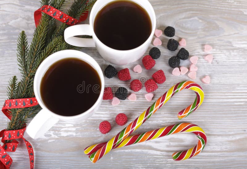 Christmas coffee, sugar cane, spruce twig on a gray background. Christmas coffee, sugar cane, spruce twig on a gray background