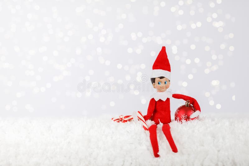 Weihnachtself auf einem Snowy-Shelf mit Peppermint-Sticks und Ornament