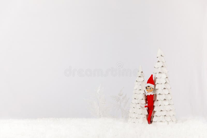 Weihnachtself Versteckt von Bäumen auf einem Schneeschlitten